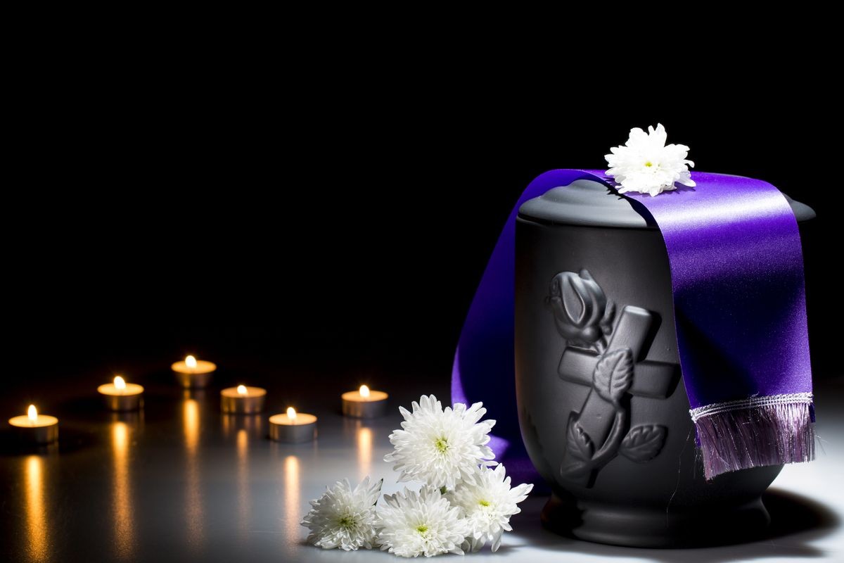 Black cemetry urn with pink tape and white chrysanthemum
